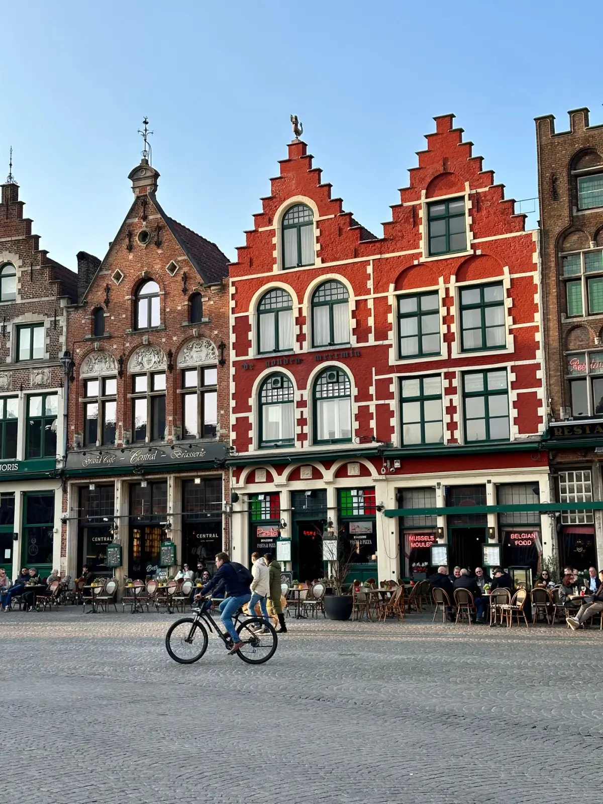 A cyclist crossing the Market Square in Bruges