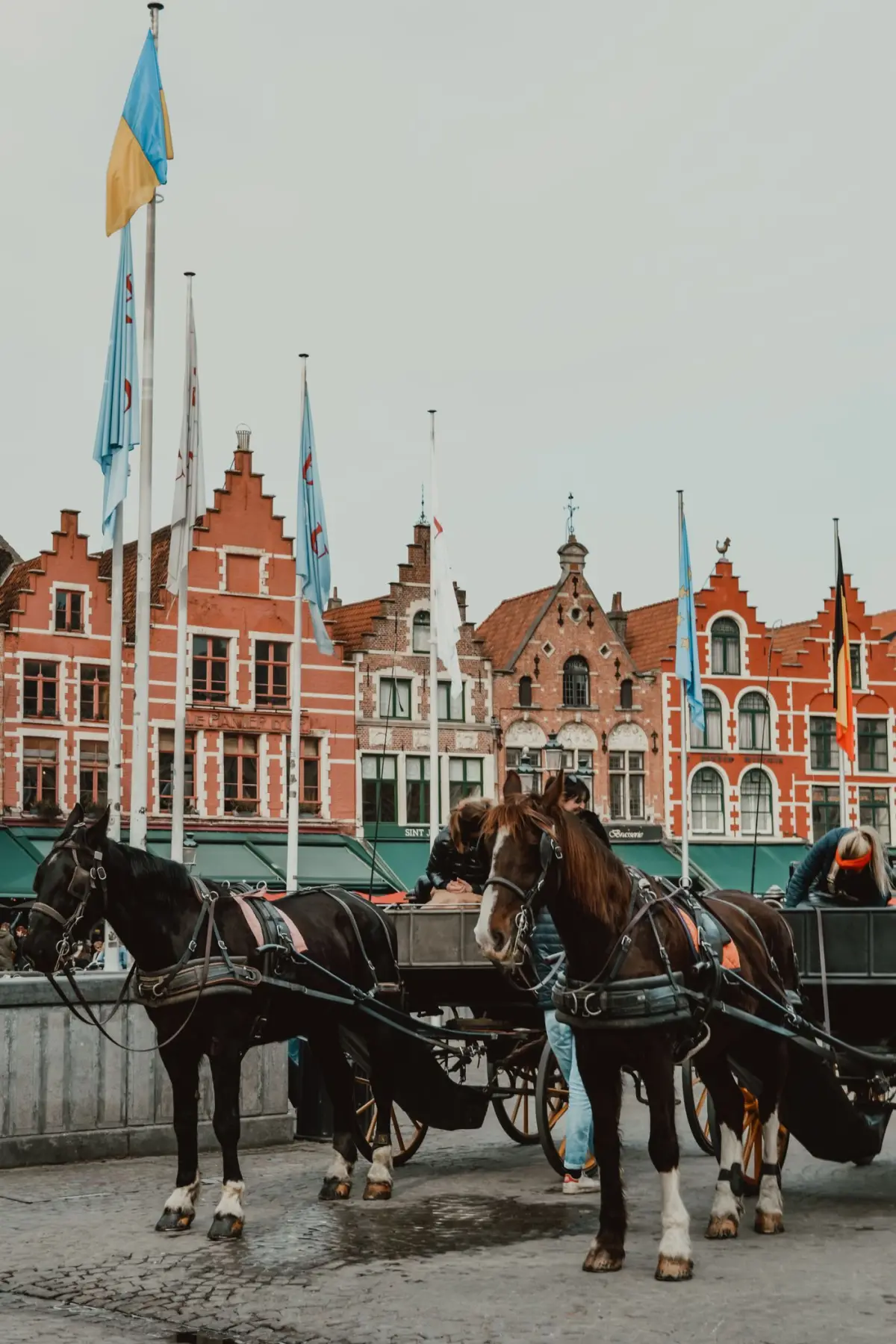 Horse-drawn carriages on the Market Square in Bruges
